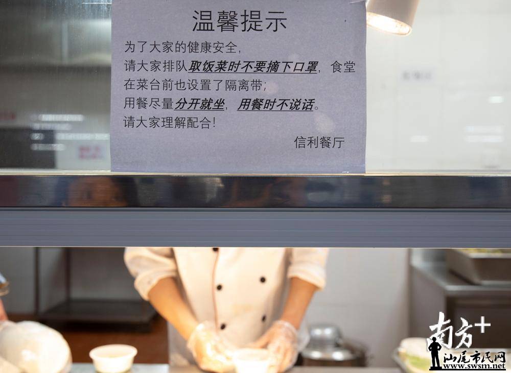 食堂取餐口出贴出了取餐时要戴口罩,尽量分开就坐的提示.